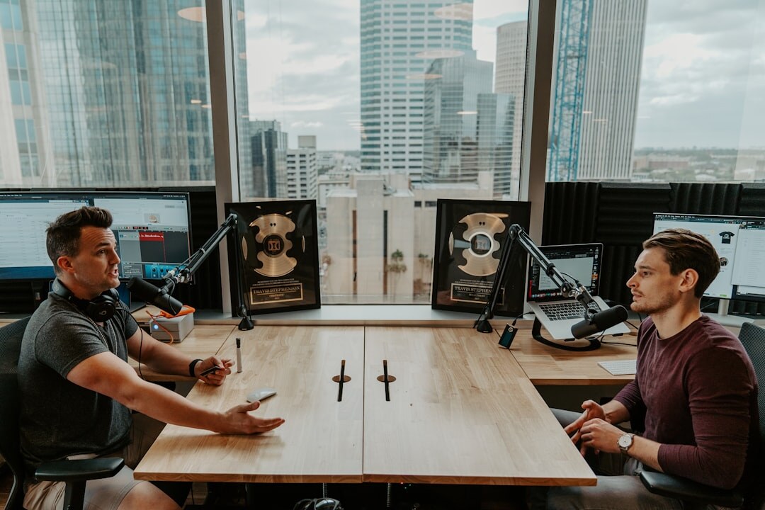 Two hosts recording a conversation for a podcast